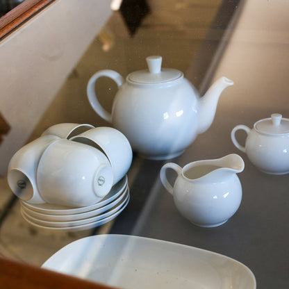 White Arzberg porcelain teapot, cups, and creamer on a reflective surface
