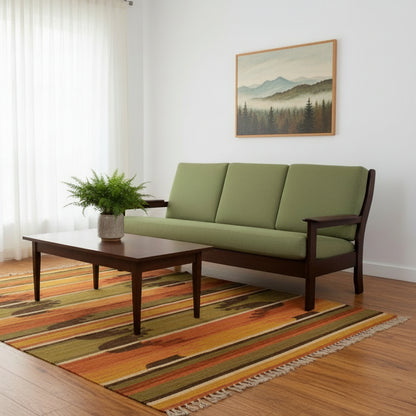 Sofa with green cushions and wooden frame on a white background